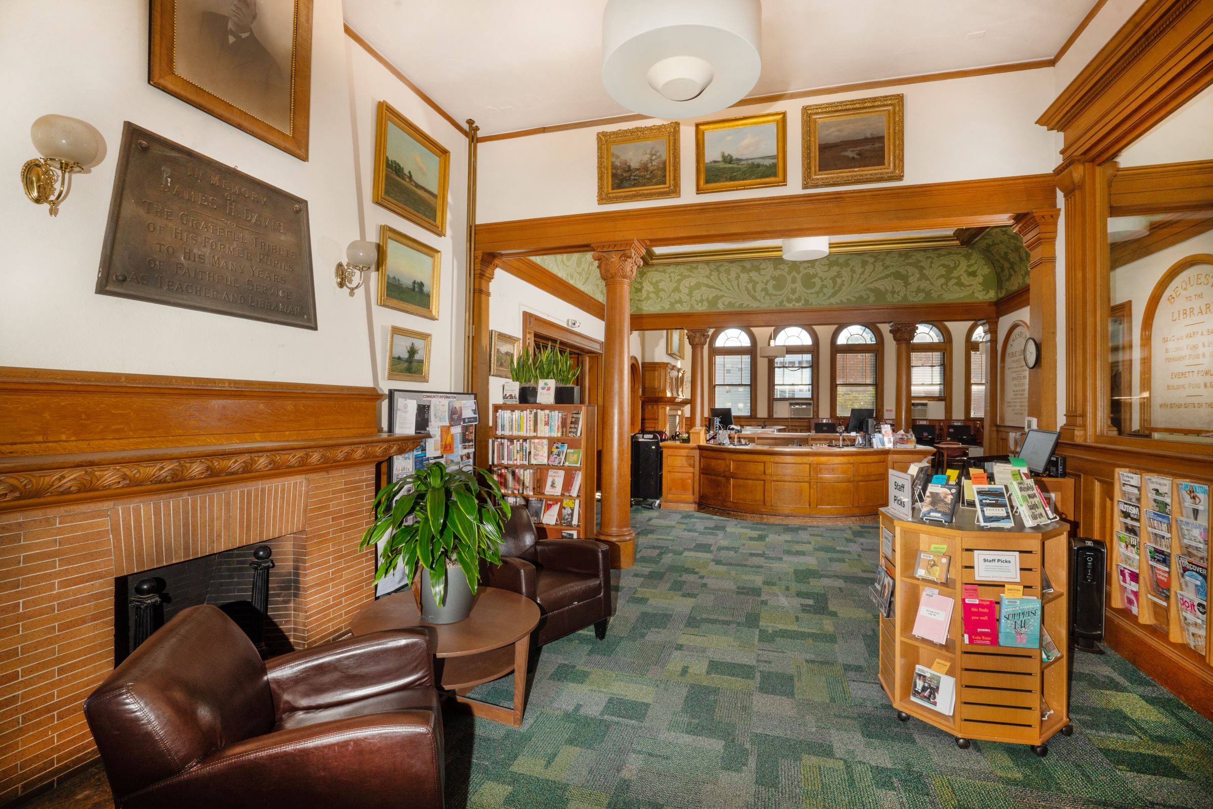 view of the New Room showing two armchairs, new nonfiction books, circulation desk, staff picks display, and new magazines